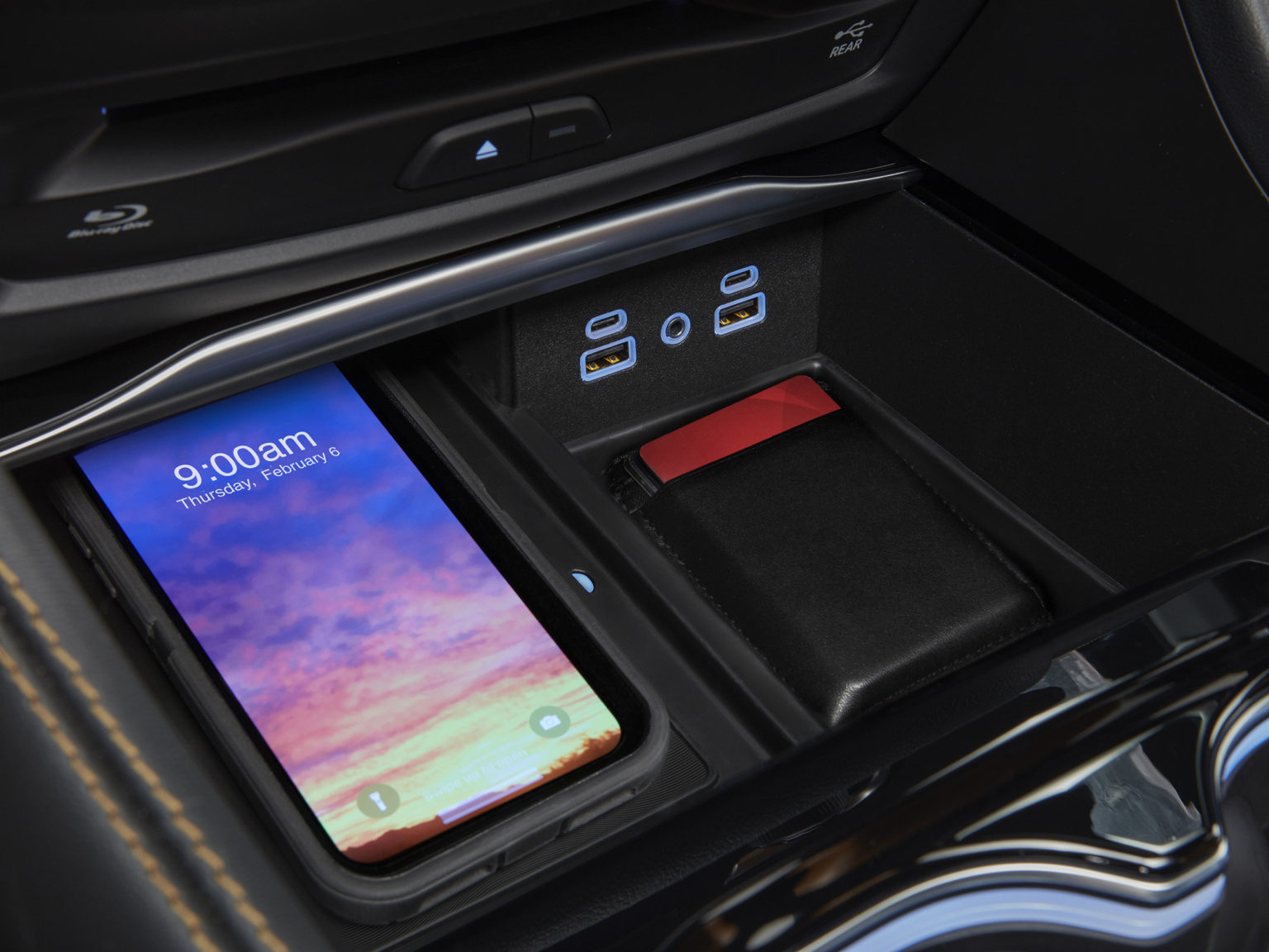 2021 Chrysler Pacifica Pinnacle interior with the new integrated Ultra console. A new LED light feature on the wireless charging system provides information on the charging status: a blue light indicates charging, red a foreign object detected and green signifies charging is complete.
