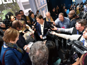 Journalists gather around Jim Farley, then-Ford executive vice president and president of global markets, during the media days at the 2018 North American International Auto Show.